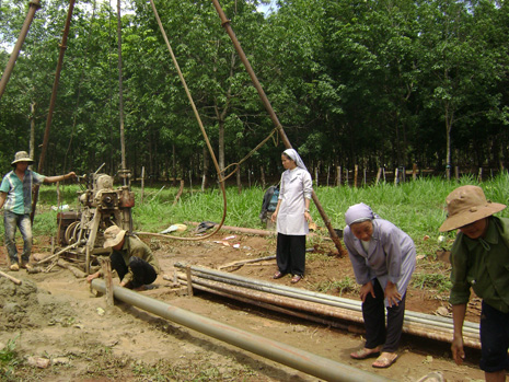 Các nữ tu và thợ đang khoan giếng tại làng Grông.