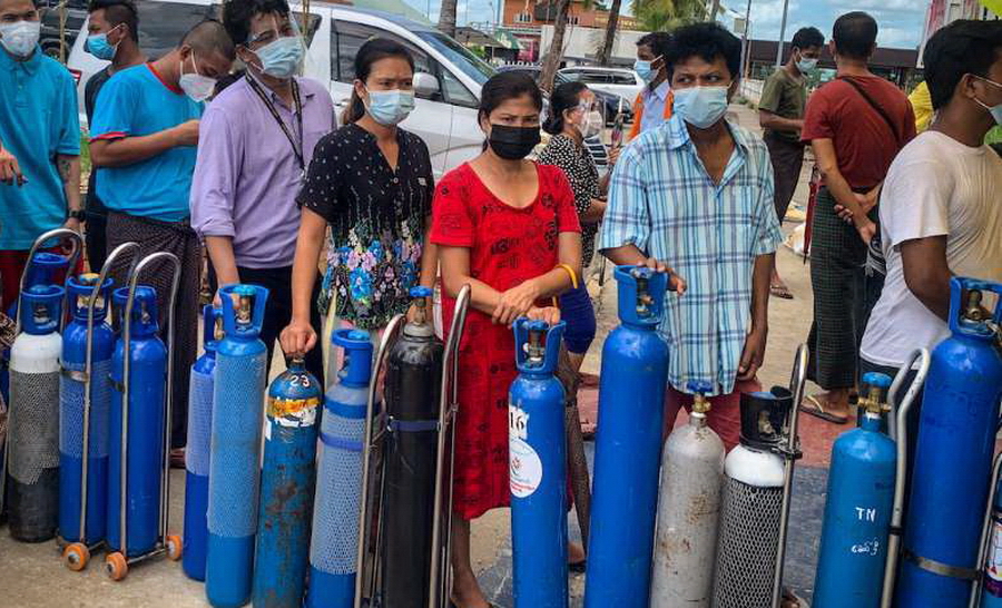 Người dân bất chấp lệnh giới nghiêm quân sự khi chờ đổ đầy các bình oxy ở Yangon vào ngày 14 tháng 7 trong bối cảnh số ca mắc bệnh Covid-19 ở Myanmar tăng vọt. (Ảnh: AFP)