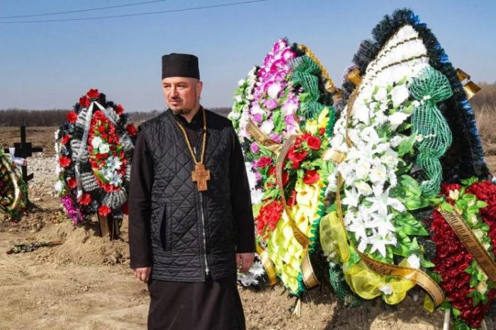 Linh mục Dmytro Povorotnyi bên các ngôi mộ của người lính Ukraine đã hy sinh trong chiến tranh.